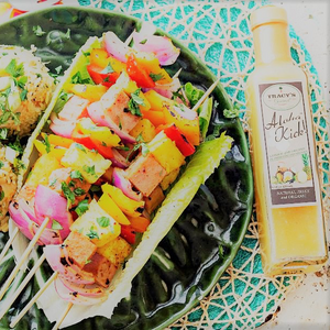 Delicious veggie shrimp kabobs with bottle of pineapple vinaigrette beside it on the table